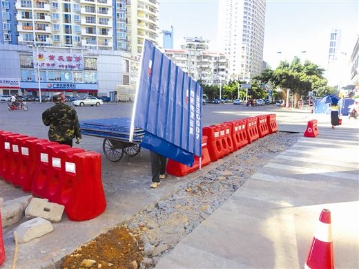 7月11日,南宁金湖南路和汇春路交汇的十字路口,施工单位正在给开挖点安装施工围挡。南国早报记者 郭燕群摄