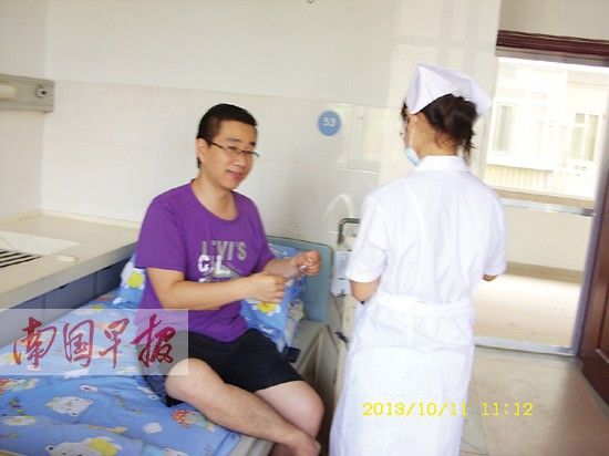 儿童病房里，“护士阿姨”给杨先生测量体温。南国早报 记者 黄乒宾