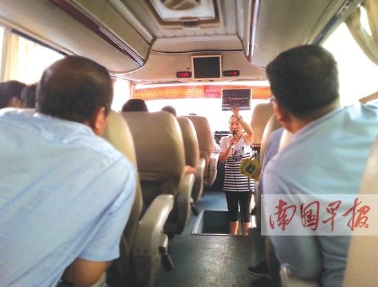 导游在大巴上为游客讲解南宁发展大环境。