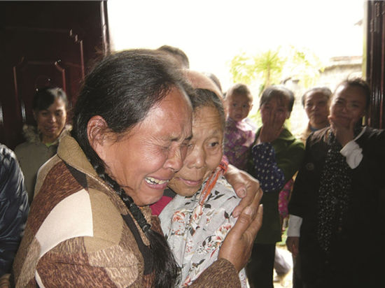 谭彩奋（左）抱着继母泣不成声。
