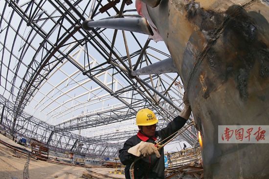 图为工人为吊装升顶施工氧焊。记者 唐辉吉 摄