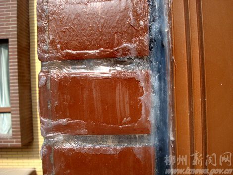 物业在张先生的房子外墙上刷胶水。