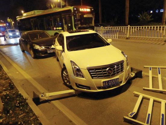 被隔离栏砸到的白色小车紧急刹车后，被后面的小车追尾。图片来源：南国早报