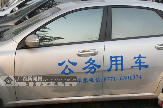 车身上贴有“公务用车、举报电话”标识的公务用车。图片来源：广西新闻网