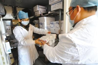 2013年12月31日，广西上思县疾控中心，工作人员将刚调拨来的、产自北京的重组乙型肝炎疫苗放进冷库。梁富盈 摄