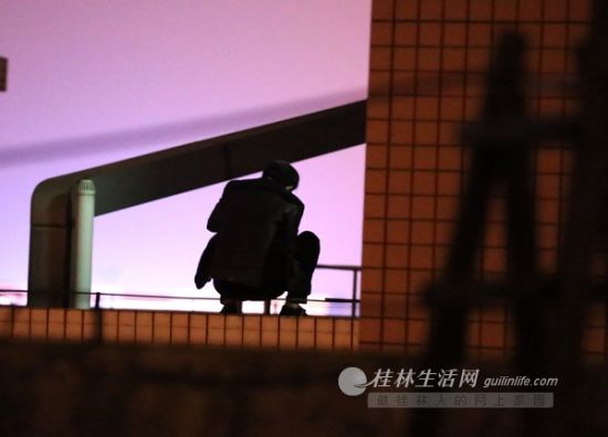 1月5日，打算轻生的男子蹲在19楼的天台上。　桂林生活网记者 李凯 摄