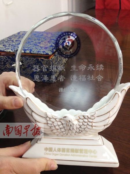 桂林红十字会负责人向器官捐献者李次元的家属颁发的水晶纪念座。记者 唐晓燕 摄 