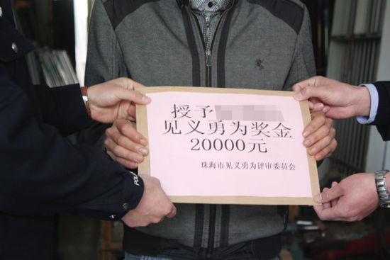 1月14日，武鸣县公安局民警将两万元见义勇为奖金交到苑刚手中。武鸣公安局供图