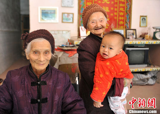 资料图：超过百岁的黄妈干(右)与黄妈学(左)，新中国成立前先后嫁给了广西巴马瑶族自治县甲篆乡平安村巴盘屯的黄卜干(已去世)。她们用仁慈和善良，演绎了世界长寿之乡巴马“为仁者寿”的传奇。中新社发 蒋雪林 摄