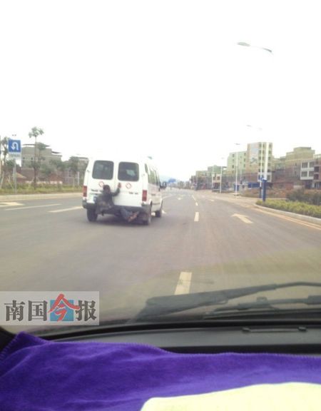 图为网友发布在微博上的“奇葩”男子挂在救护车车尾的照片。