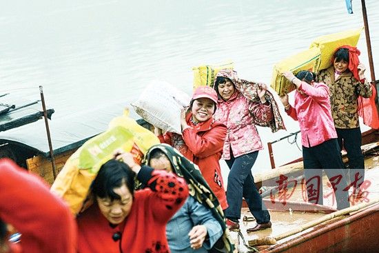 妇女们背起大包货物下船。 记者 邹财麟 摄