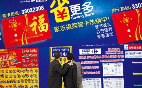 3月11日，顾客在深圳一家家乐福超市查看折扣信息。新华社发 