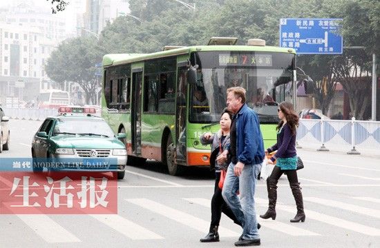 3月18日，南宁市民主路一斑马线前，公交车、出租车在斑马线前停车，礼让市民通过。