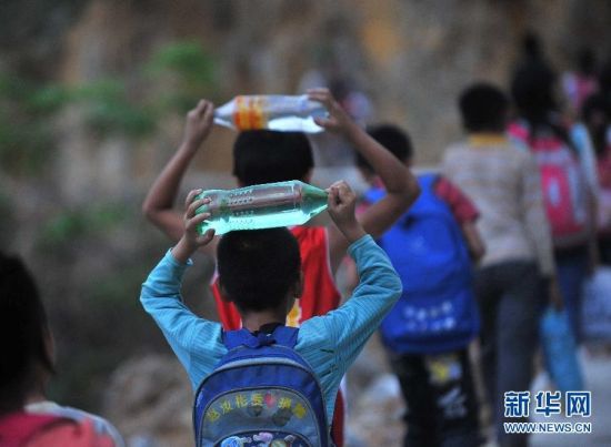 广西凌云县山区学生带水上学。