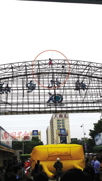 小刘爬上20米招牌铁架上欲轻生。 记者 周伟武摄