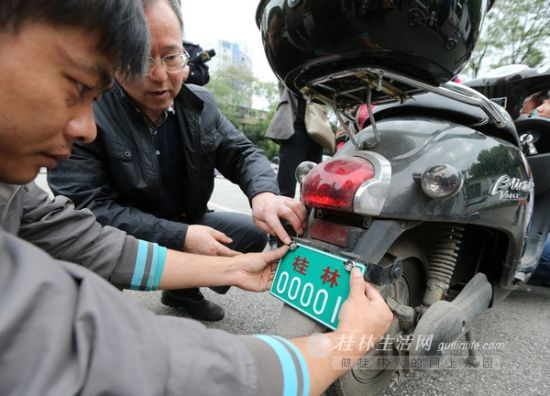 工作人员在为领到“桂林00001”临时车牌的电动自行车上牌 来源：桂林生活网-桂林晚报 记者李凯 实习生高磊盈 摄 