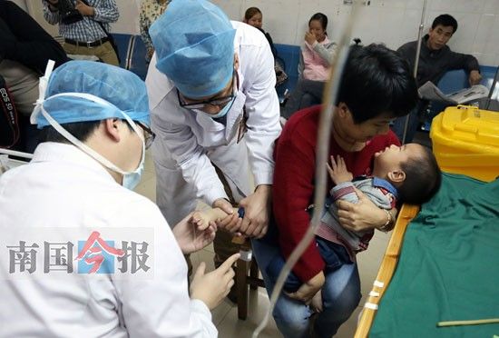 龙成（左一）和韦侠（左二）在帮小患者进行静脉注射。在急诊科里，不少人点名让男护士帮打针。记者陈新援 摄 